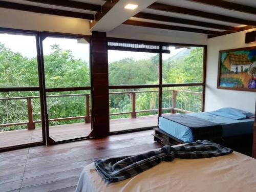 a bedroom with two beds and large windows at Moon Wind Tayrona Hostel by Rotamundos in El Zaino