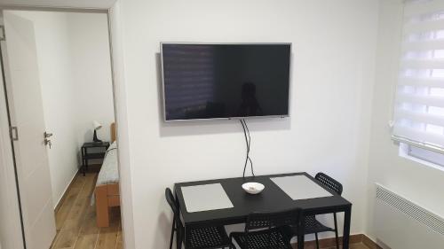 a black table with chairs and a television on a wall at MK Zlatibor in Zlatibor