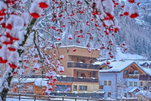 ein Gebäude im Hintergrund mit Schnee auf den Bäumen in der Unterkunft Hotel La Val in Valdidentro