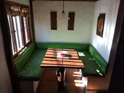 Habitación con sofá verde y mesa. en LAWIL Cabaña en Tandil
