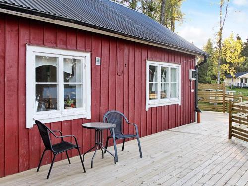 un edificio rojo con 2 sillas y una mesa en una terraza en 7 person holiday home in SKYLLBERG, en Skyllberg