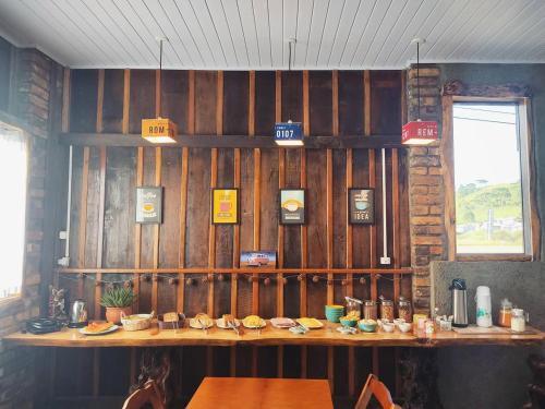 a restaurant with wooden walls and a table with food at Pousada Rota da Kombi in Bom Jardim da Serra