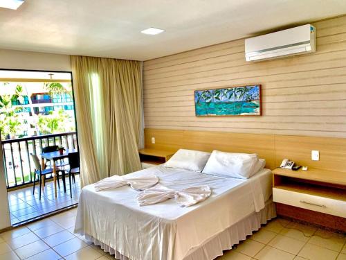a hotel room with a bed and a balcony at Marulhos Resort Muro Alto Studio in Porto De Galinhas