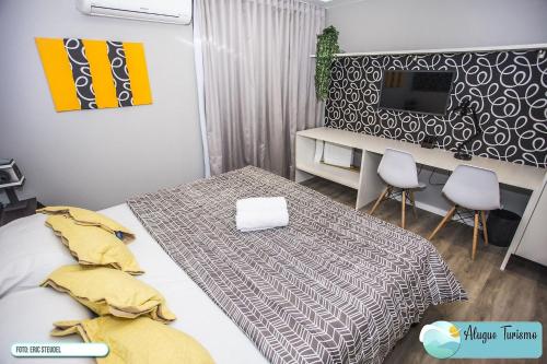 une chambre avec un lit, un bureau et une télévision dans l'établissement Apartamento 615 - All You Need, à Curitiba