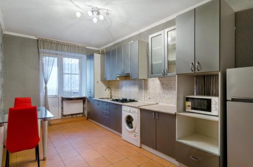 スームィにあるGood Homeのキッチン(青いキャビネット、赤い椅子付)