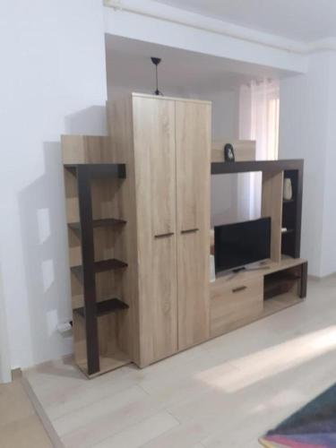 een houten entertainmentcentrum met een flatscreen-tv bij Luxury 1 Bedroom Apartment in Roşu