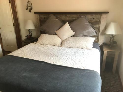 ein Schlafzimmer mit einem großen Bett mit Kissen darauf in der Unterkunft Grand Canyon Cottage at Historic Wrigley Ranch with Horseback Riding & Shooting in Parks