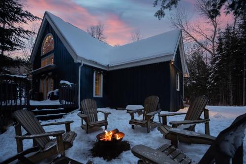 a group of chairs around a fire pit in the snow at Maison Napoléon B&B in Mont-Tremblant