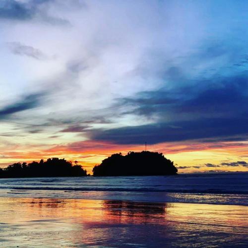 an island in the ocean with a sunset at Cabaña Villa Sofi in Nuquí