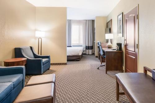 a hotel room with a couch and a bed and a desk at Comfort Suites in Fort Stockton