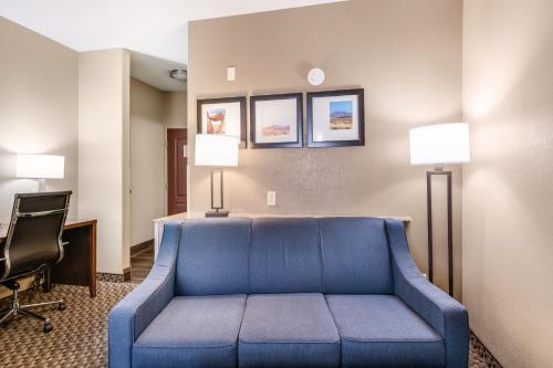 a living room with a blue couch in a hotel room at Comfort Suites Fort Stockton in Fort Stockton
