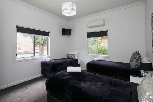 een woonkamer met 2 bedden en een bank bij 2easy on Chapel in Bendigo