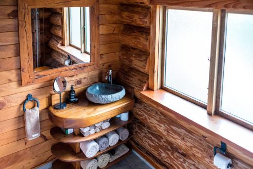 a bathroom with a sink in a log cabin at Cascade Creek Retreat in Milton
