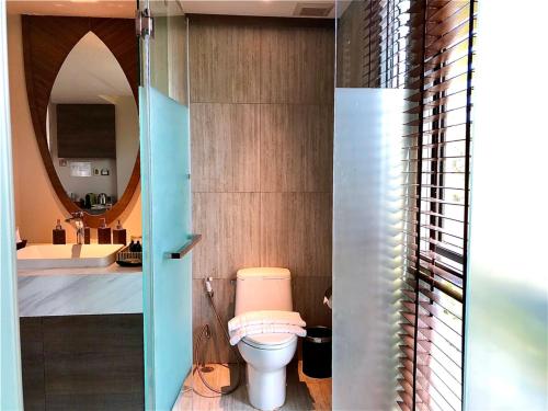 a bathroom with a toilet and a sink and a mirror at Green Pix Khaoyai in Pak Chong