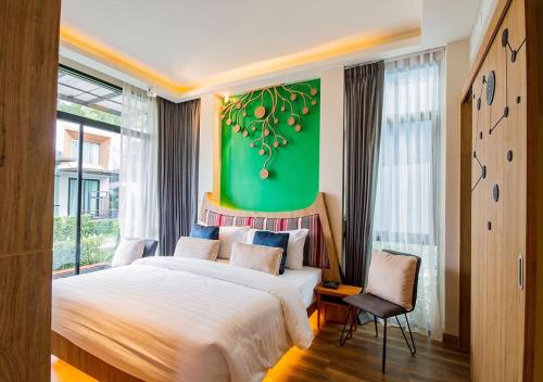 a bedroom with a large bed and a green wall at Green Pix Khaoyai in Pak Chong