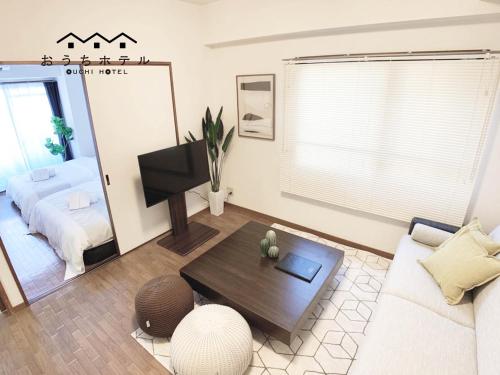 uma sala de estar com um sofá e uma mesa em OUCHI HOTEL Dambara em Hiroshima