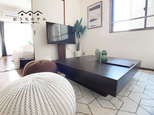 a living room with a tv and a coffee table at OUCHI HOTEL Dambara in Hiroshima