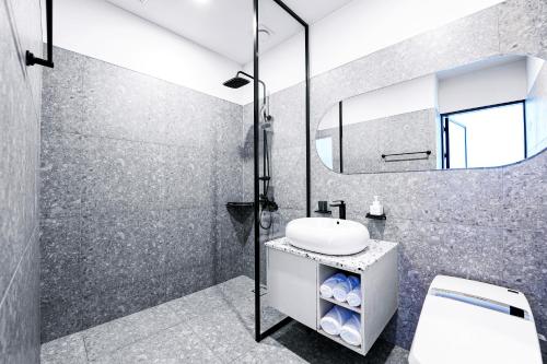 a bathroom with a shower and a sink and a mirror at Ocean The Point Hotel in Busan
