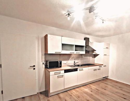 a kitchen with white cabinets and a sink at Tiroler Bergnestl in Imst