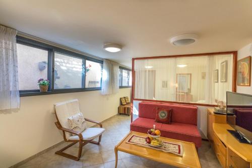 a living room with a red couch and a desk at Margo Zimmer in Midreshet Ben Gurion
