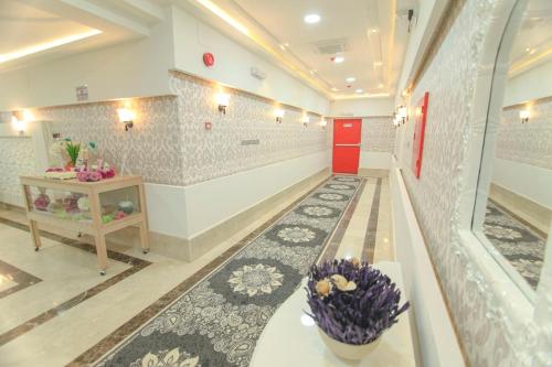 a hallway with a vase on a table in a room at سكنا للشقق الفندقية in Buraydah