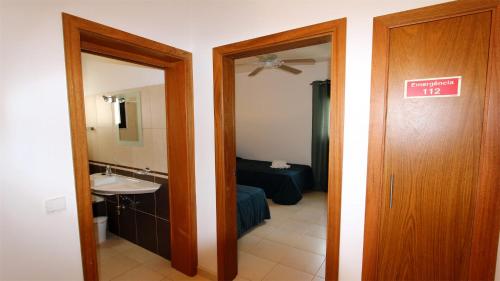Habitación con baño con lavabo y espejo. en Terraços do Mar 46- Clever Details, en Vilamoura