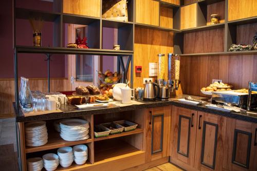 a kitchen with a counter with plates and food at Ice Angels Hotel in Borovets