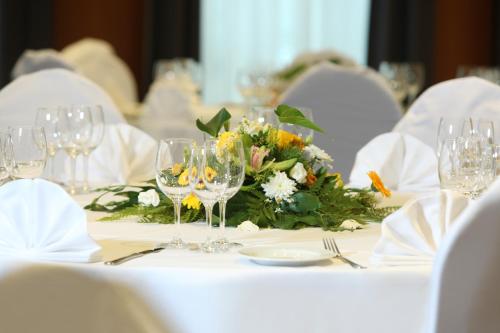a table with glasses and a bouquet of flowers on it at ibis Styles Luzern in Luzern