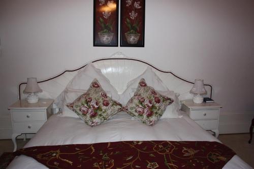a bed with two pillows on it with two night stands at Karoopark Guest House in Graaff-Reinet