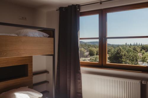 a bedroom with a large window with a mountain view at Robbesscheier in Munshausen