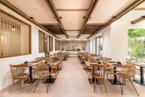 an empty restaurant with tables and chairs at Matala Bay Hotel in Matala