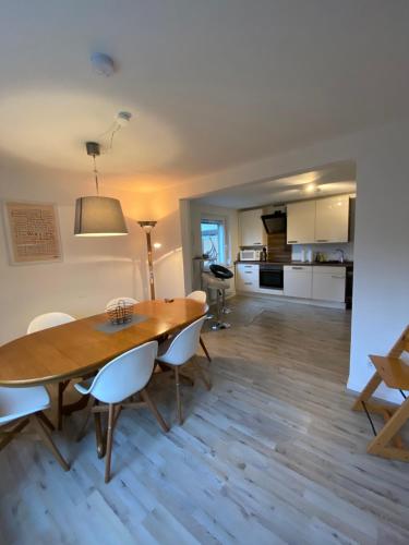 a dining room and kitchen with a wooden table and chairs at über den Dächern von Neheim in Arnsberg