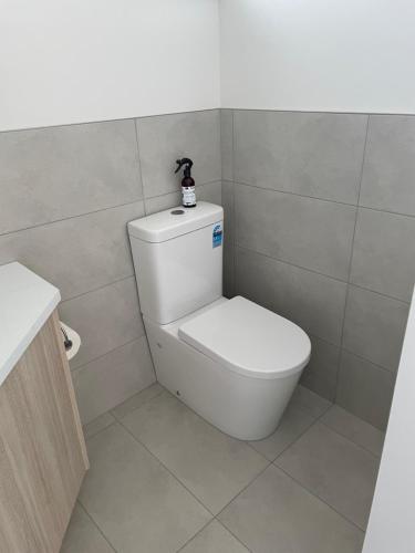 a bathroom with a toilet with a black toy on top of it at Jetty's End Bicheno in Bicheno