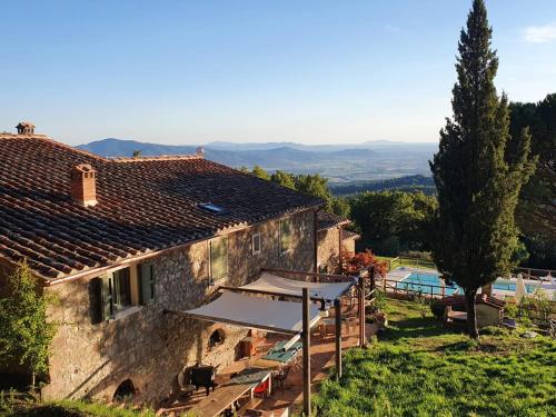 - une vue extérieure sur une maison avec une piscine dans l'établissement B&B Podere Camaiano, à Roccastrada