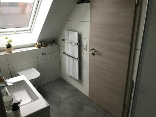 a bathroom with a sink and a toilet and a window at FEWO Salzwedel, Zum Dorfplatz in Salzwedel