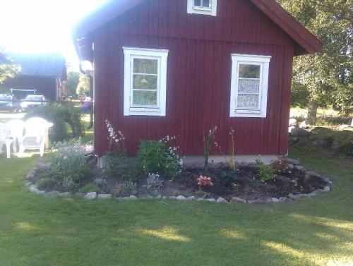 a red house with a garden in front of it at Stensholms Trädgård in Nässjö