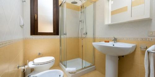 a bathroom with a toilet and a sink and a shower at Casa Jenny in San Vito lo Capo