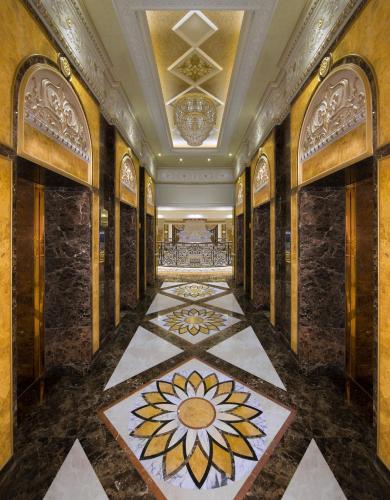 a hallway with a tile floor with a flower on it at Royal Rose Abu Dhabi, a Curio Collection by Hilton Affiliated Hotel in Abu Dhabi