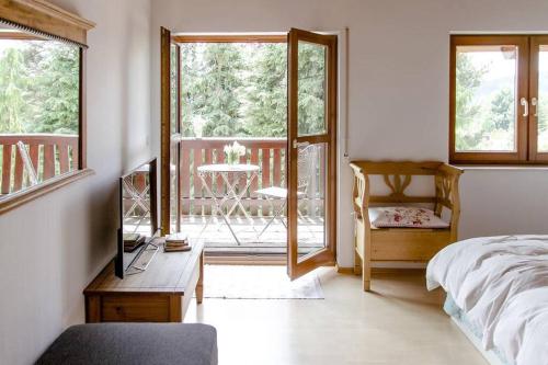 a bedroom with a bed and a balcony with a table at 4-Zimmer-Ferienwohnung Waldblümle in Dobel