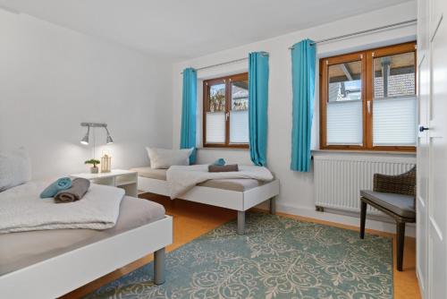 1 Schlafzimmer mit 2 Betten, einem Sofa und Fenstern in der Unterkunft TTP Apartments Immenstaad in Immenstaad am Bodensee