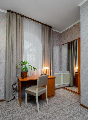 a room with a desk and a chair and a window at Hotel Vizit in Cherepovets