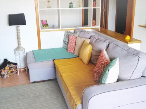 a couch with pillows on it in a living room at Hilltop Azores - Beach & Countryside in Porto Formoso