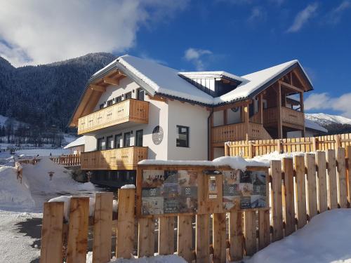 a house in the snow with a wooden fence at DAVID SUITEN in Mauterndorf