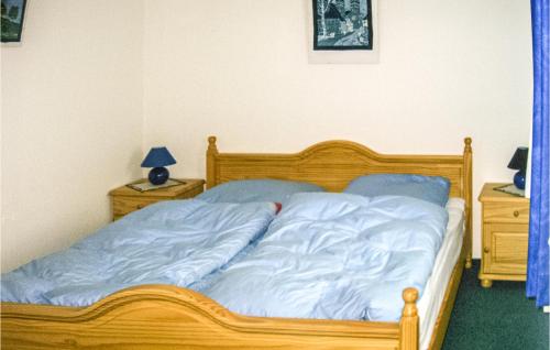 um quarto com uma cama de madeira com lençóis azuis em Awesome Apartment In Insel Poel With Harbor View em Insel Poel
