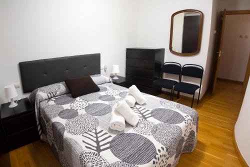 1 dormitorio con cama y espejo en Piso en c/ Casta Álvarez, en Zaragoza