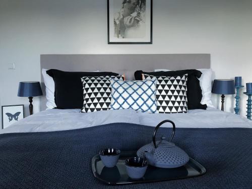 uma cama com uma bandeja com copos em House of Cocagne em Kockengen