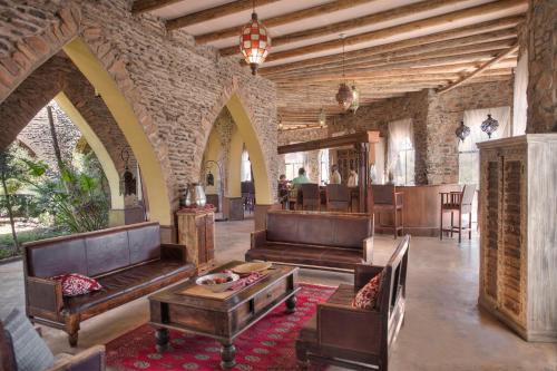 a living room with leather couches and a table at Le Mirage Resort & Spa in Sesriem