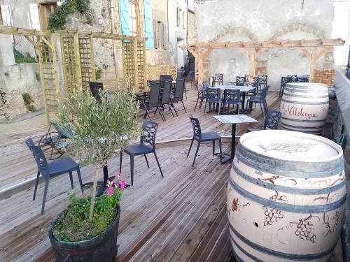 a patio with a table and chairs and barrels at Au Château de Villelongue B&B in Villelongue-dʼAude