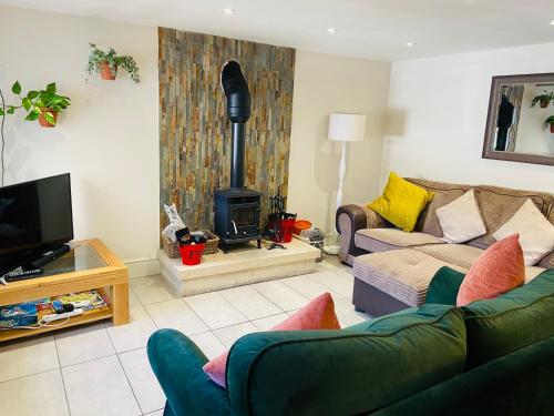 a living room with a couch and a fire place at The Stables in Bakewell