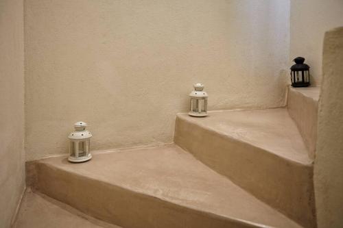 three candles sitting on the steps of a building at Summer House in Santorini in Foinikiá